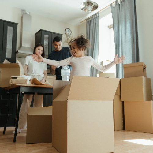 A joyful family unpacking boxes in their new home, highlighting family closeness and excitement.